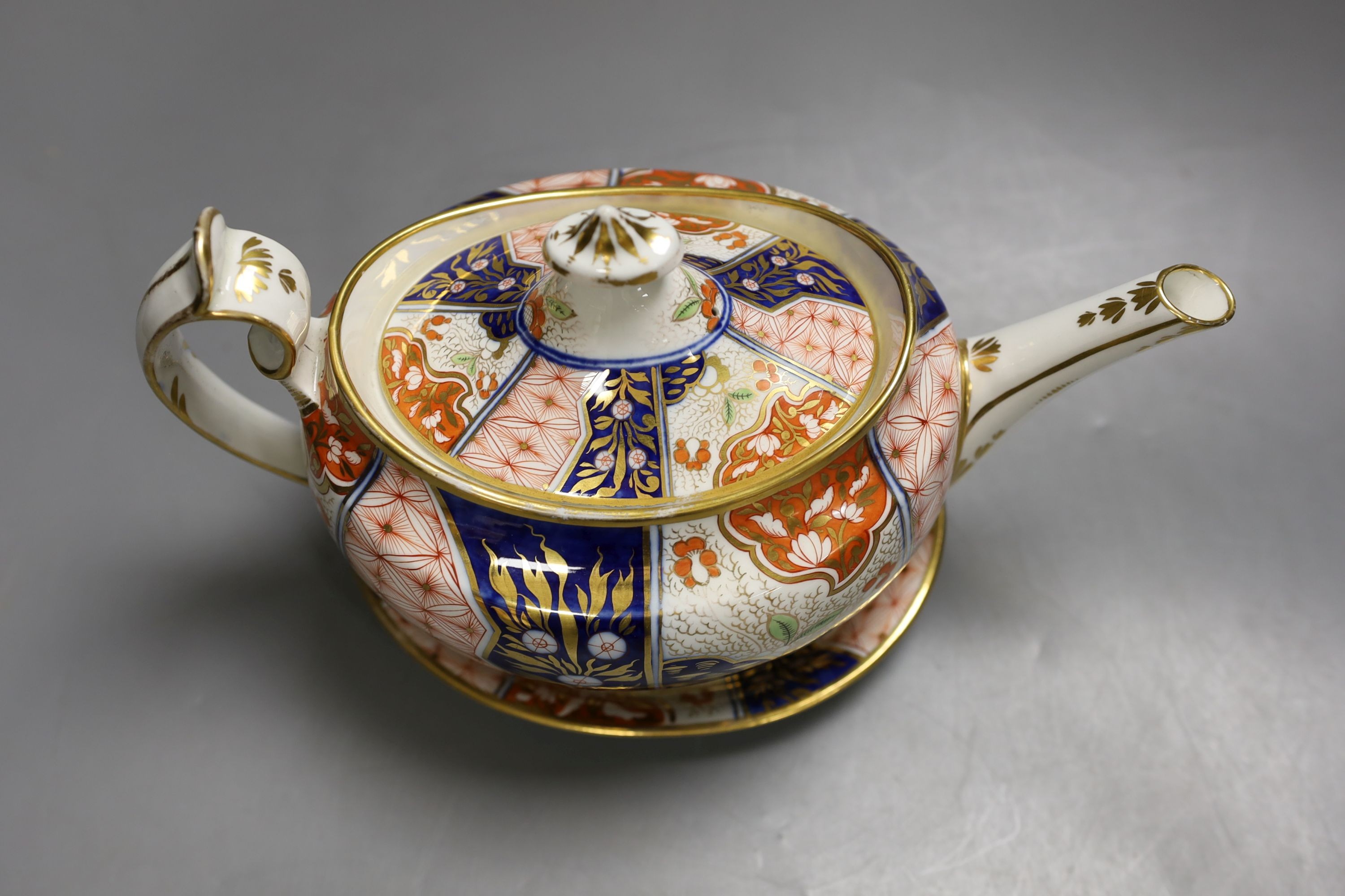 A Chamberlain teapot cover and stand painted with an Imari pattern, c.1810, 26cm long